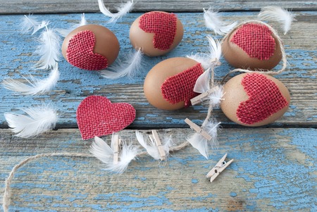 Easter eggs and feathers on an old wooden surfaceの写真素材