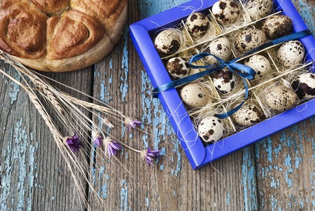 Easter Decor quail eggs in box, on a wooden surfaceの写真素材