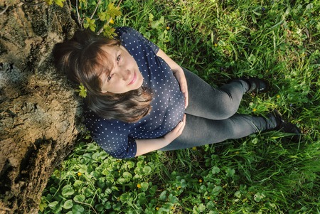 Pregnant woman in a spring parkの写真素材