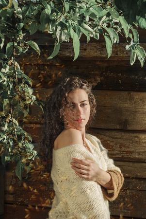 Beautiful young woman dressed in a knitted cardigan in a spring gardenの写真素材