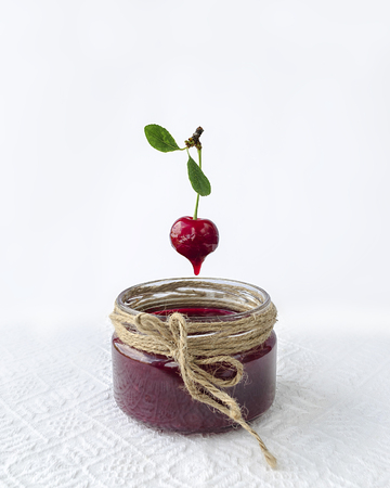 Cherry jam and cherry berry on white backgroundの写真素材