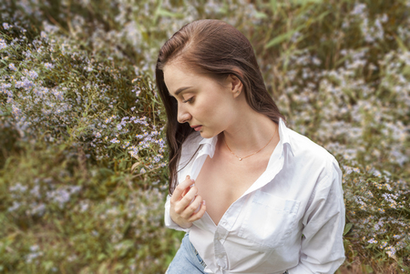 beautiful sad girl in white blouse thought, against summer park.の写真素材