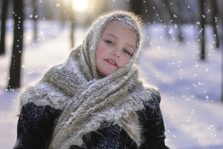 Beautiful little girl in shawl in winterの写真素材