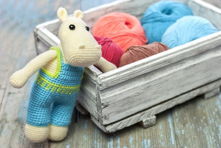 Knitted toy hippopotamus on a wooden backgroundの写真素材