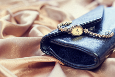 Vintage old clock lying on black clutch bag . Close-up photo.の写真素材