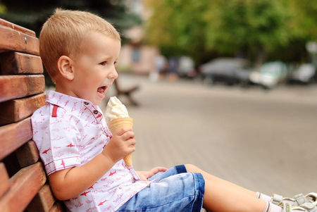 Happy little boy eating ice cream with copy spaceの写真素材