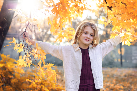 Little laughing pretty girl in autumn parkの写真素材