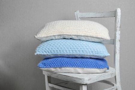 knitted pillows on a chair, blue color range, handmadeの写真素材