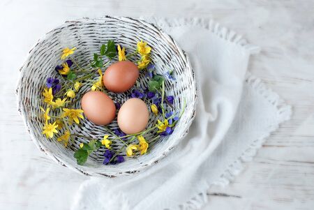 Easter eggs near flowers on wooden background, flat lay view of easter eggsの写真素材