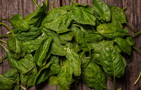 spinach on a wooden background with drops. Top viewの写真素材