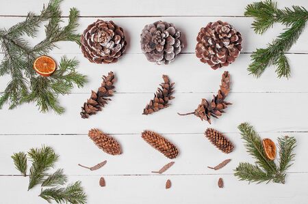 Decoration from pine cones, orange slices and fir branches on the white wooden table. Empty space. Top view.の写真素材