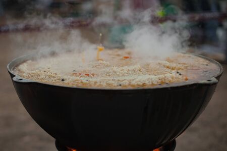 Cauldron with pilaf. Pilaf boils in a cauldron. Street foodの写真素材