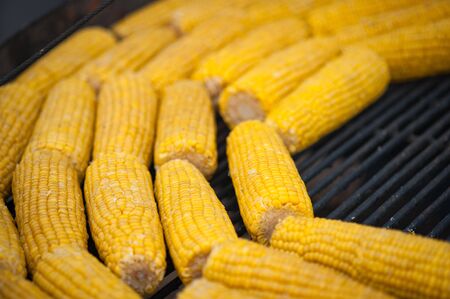 Grilled corn. Street food festival. Close up of appetizing grilled sweet corn on the bbq grill....