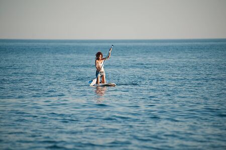 Stand Up Paddling in the sea. SUP. Women Training on Paddle Board