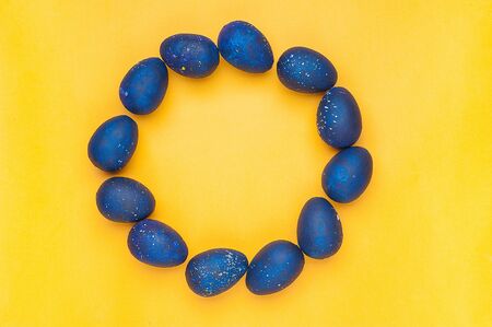 Blue eggs on a yellow background. Circle shape. trendy Easter egg of color of the year-classic blue, Top view. Flat lay. The object in the center of the photo.の写真素材