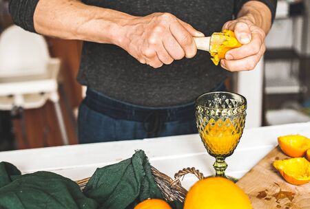 The man making orange juice at home. Preparation of orange fresh. Healthcare concept. Soft focus