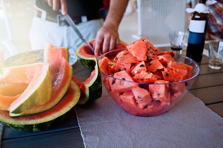 A man cuts a watermelon into slices.の写真素材