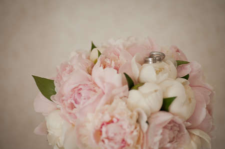 Two wedding rings on a delicate wedding bouquetの写真素材