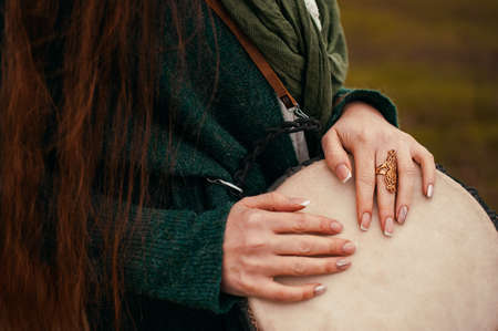 A girl with red hair plays the djembe. African drumの写真素材