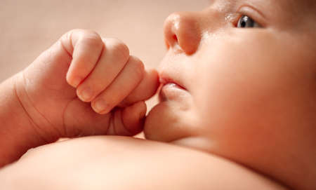 Portrait of a baby boy on a beige background.の写真素材