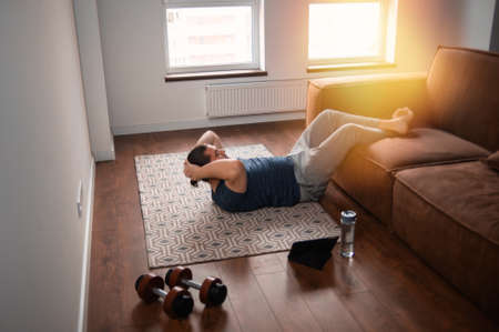 Young man working out online at homeの写真素材