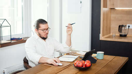 Young man during self-isolation works in the kitchen at home