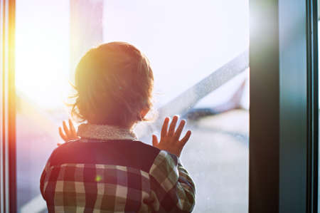 Boy looks out the window at the airportの写真素材