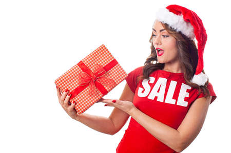 Woman in red clothes looking at the gift box over whiteの写真素材