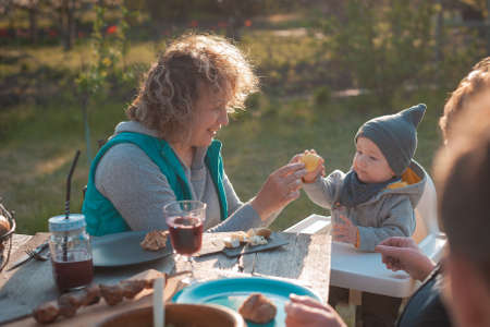Woman with small child sitting at a wooden table in the garden Easterの写真素材