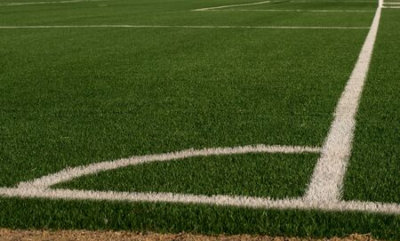 Artificial green grass and white border lines. Artificial turf for soccer field. Football field in an outdoor stadium. Selective focus.の写真素材