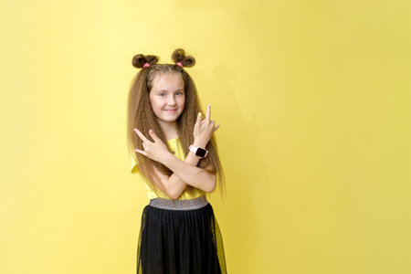Cool cute girl with a trendy hairstyle in a yellow top on a yellow background with bright emotionsの写真素材