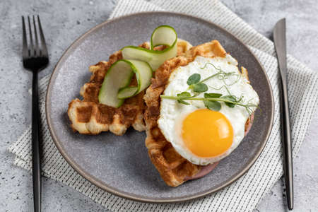 Breakfast with unsweetened croffles (Croissant waffle), fried egg and vegetables.の写真素材