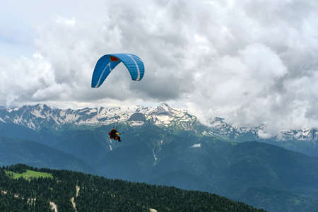 Beautiful view of snow-capped mountains with paragliders flying in tandem. Extreme sport.の写真素材