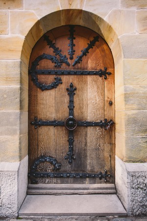 Old brown weathered wooden door with iron decorationの写真素材
