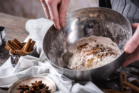 Human hands mixing Ingredients for making cookies with spoon