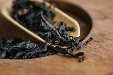 Dry green tea leaves in wooden spoonの写真素材