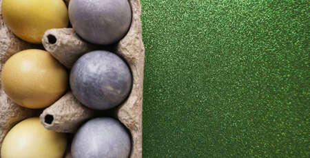 painted eggs for easter yellow and gray in a cardboard egg holder