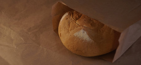 round fresh bread in a paper bag close-upの写真素材