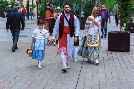 A family in beautiful traditional festive attire walking in the street during the spring festival of...