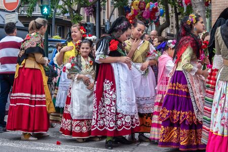 A group of people in beautiful traditional festive attire, at a procession with flowers in their hands during the spring festival of Bando de la Huerta in Murcia, Spain, on April 22, 2019.のeditorial素材