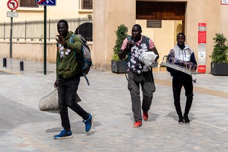 Illegal African immigrants selling badges and glasses on the streets of the city of Murcia in Spain during the spring holidays in April 2019のeditorial素材