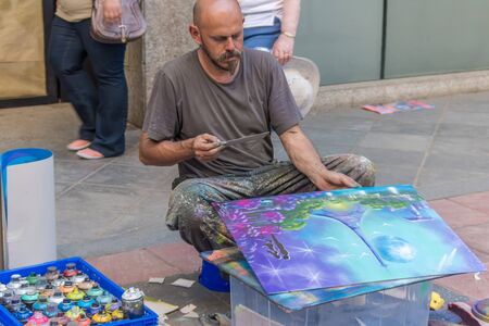 Spain, Seville, May, 3, 2017. Airbrush painter painting a beautiful abstract picture on the street during the Seville Fair.のeditorial素材