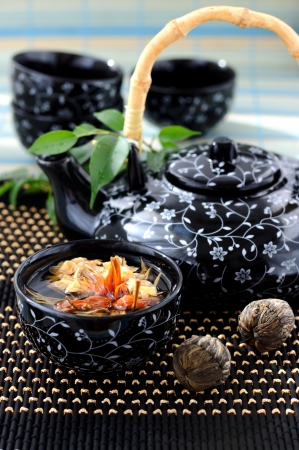 Tied green tea blossoms in a tea cup.の写真素材
