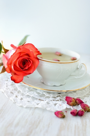 Cup of tea with dried roses and fresh roseの写真素材