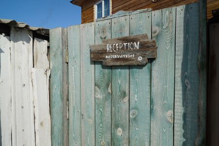 A Board with an inscription on an old wooden fence