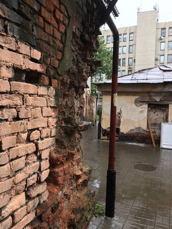 in the courtyard between the houses is an old dilapidated brick wallの写真素材
