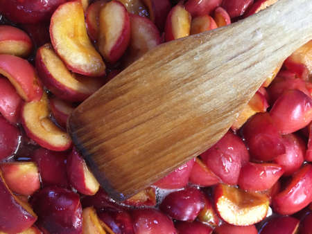 In the jam of red Apple slices is a wooden spoonの写真素材