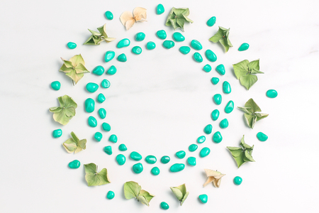 Beautiful frame of dried flowers of hydrangeas and pebbles of turquoise color. Marble background. View from above, flat layの写真素材