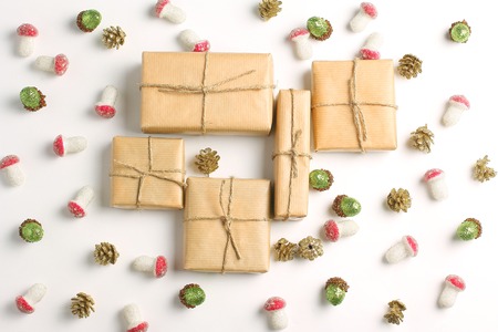 Christmas (New Year) ornaments in the form of cones, acorns and mushrooms on a white background. Gift Box packed in kraft paper. Simple flat lay composition. Holiday conceptの写真素材