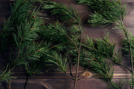 Pine branches on a wooden background. Christmas tree. Minimal concept. Flat lay, top view